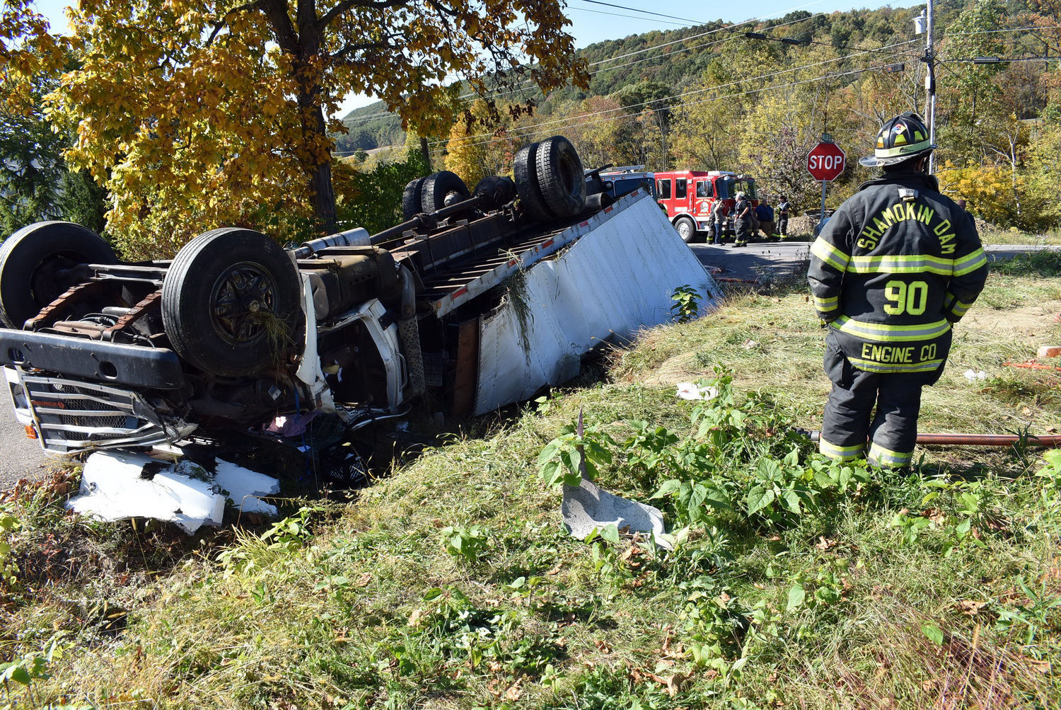 Box truck hauling apple cider flips over